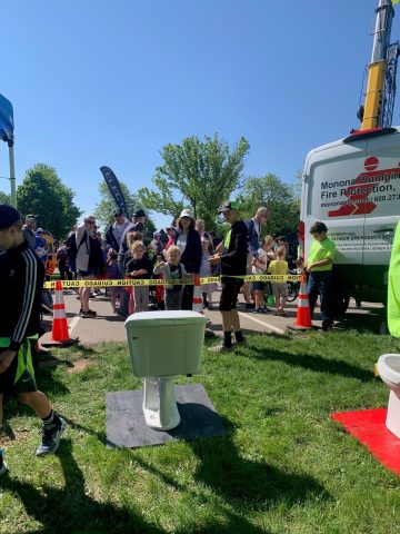 Community event with Monona Plumbing and Fire Protection services, fire safety equipment, and plumbi.