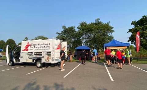 Monona Plumbing and Fire Protection team at outdoor community event.