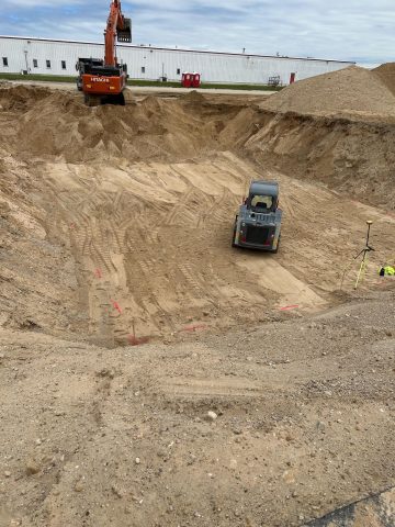 Excavation site for plumbing and fire protection systems with heavy machinery.
