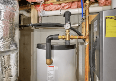 Plumbing and fire protection pipes around water heater in utility room.