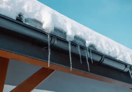 Plumbing and fire protection pipes with icicles on snowy roof.